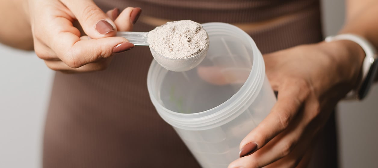 kvinna som f&ouml;rbereder proteinshake