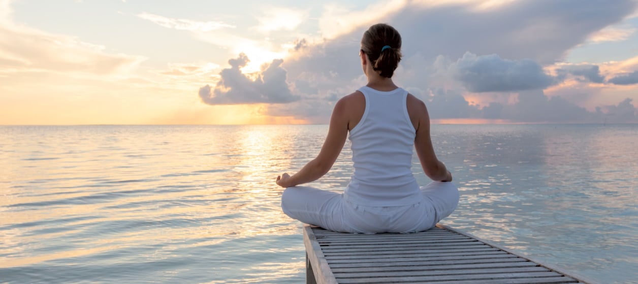 Faktorer som påverkar immunsystemet Kvinna som mediterar vid havet